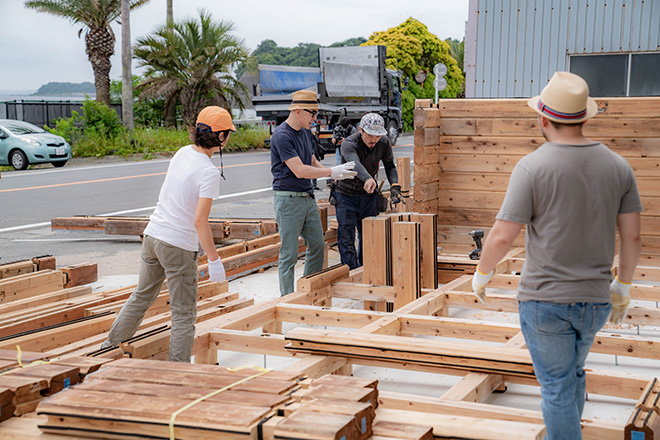 log house assembly under Hitachi creative collaboration approach